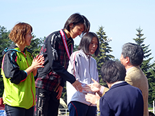 女子１００ｍ障害で滋慶学園、嶋貫顧問からメダルを授与される紫村選手と野村選手（手前）ら