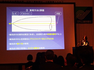 「優秀プラン発表会」で低出力半導体レーザー鍼灸針システムの開発に関するビジネスプランをプレゼンする西岡さん