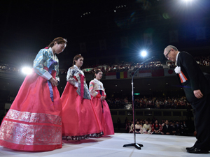 色艶やかな韓服で賞状を受けとるリ・ボラさん（左）、ガン・ウンジさん（中）、ユン・ジヨンさん（右）。